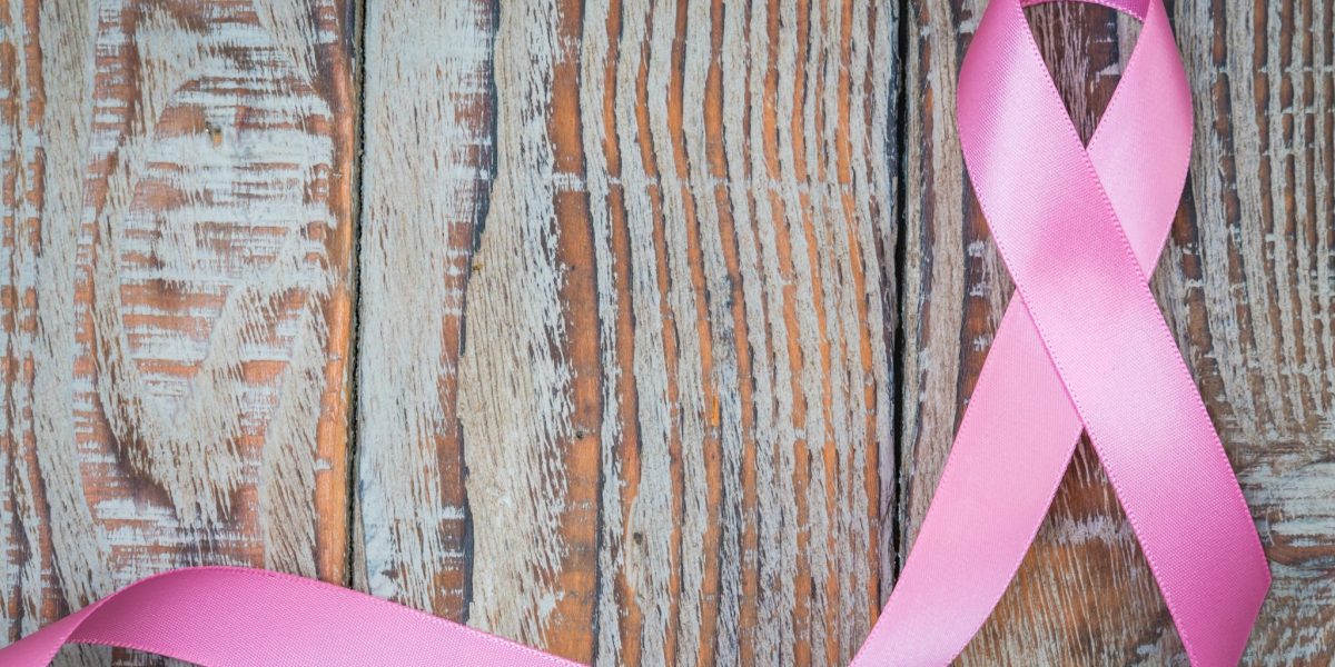 World cancer day : Breast Cancer Awareness Ribbon on wood Background